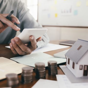 Close up male hand calculate the money for investment in property and mortgage. Finance and saving money for investment.