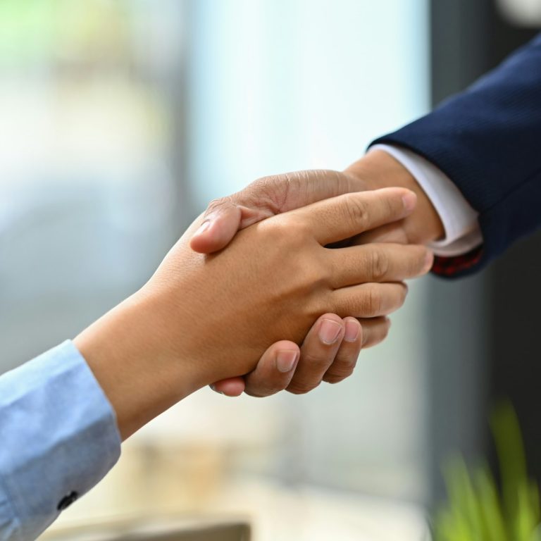 Successful businesspeople shaking hands closing deal or making agreement.